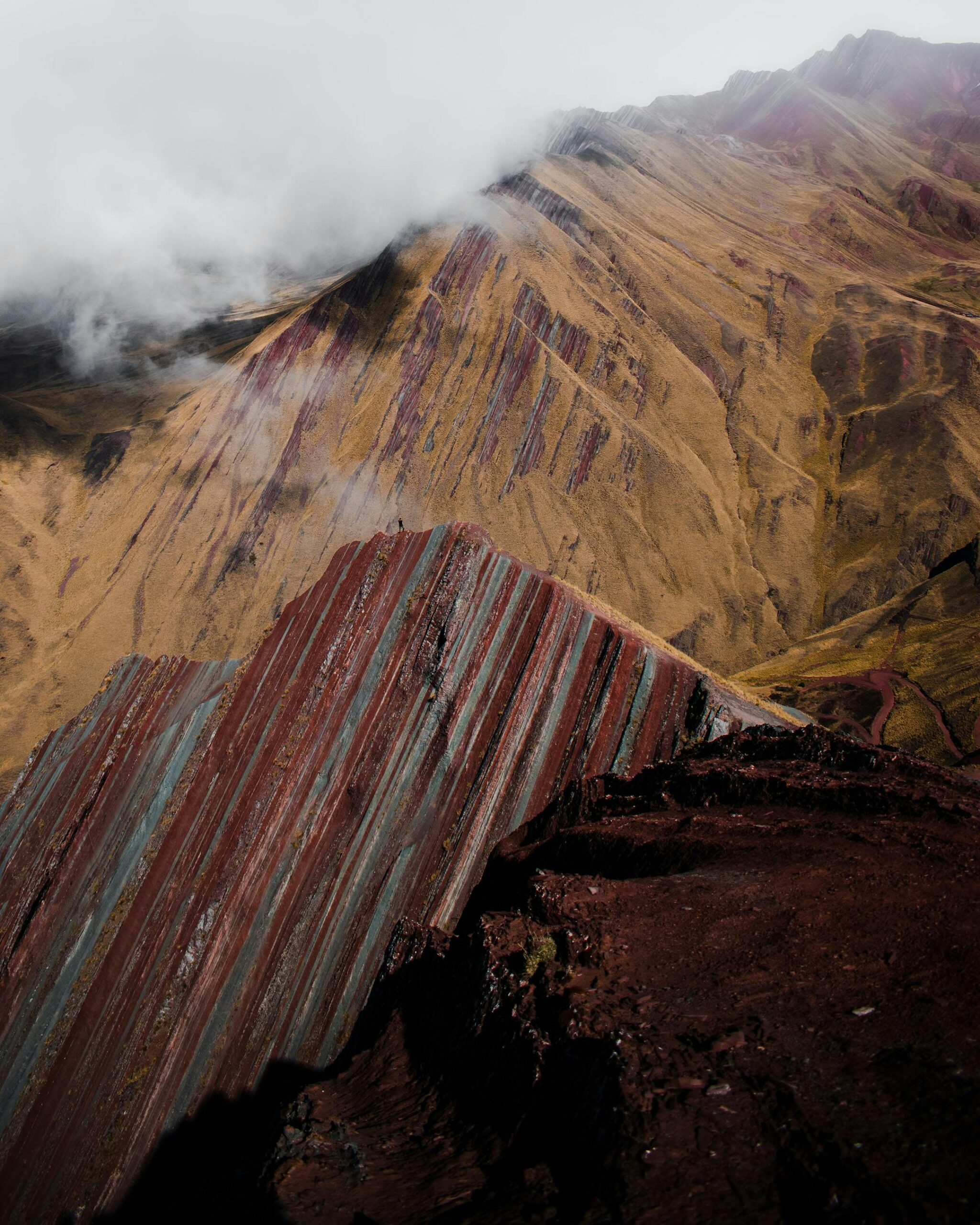 A breathtaking aerial shot of Peru's Rainbow Mountain with vibrant mineral layers.